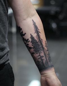 a man with a forest tattoo on his arm