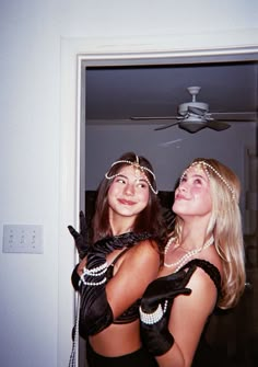 two women dressed up in flappers and garters pose for a photo together