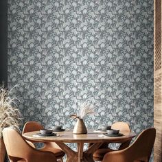 a dining room table with four chairs and a vase on top of it in front of a wallpapered background