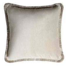 a white and grey pillow with fringe trims on the front, sitting against a white background