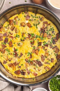 an omelet in a pan on a table with eggs and other dishes around it