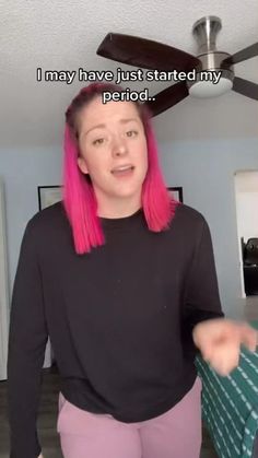 a woman with pink hair is standing in front of a ceiling fan that says, i may have just started my period