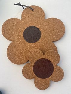 three cork coasters with brown and black circles on them, one is shaped like a flower