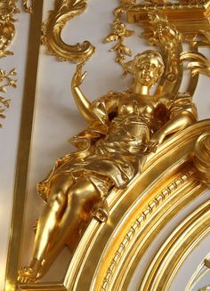 a gold clock with an image of a woman sitting on it's face and hands