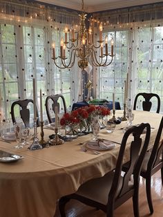 a dining room table is set with place settings for six and has candles on it