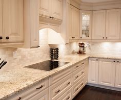 an image of a kitchen setting with white cabinets and granite counter tops in the center