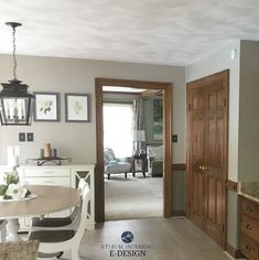 a dining room table and chairs in front of a doorway with pictures on the wall