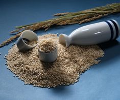 two salt shakers and some grain on a blue surface