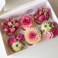 pink and white flowers in a box on a table