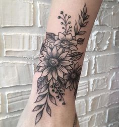 a black and white flower tattoo on the arm