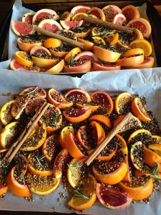 two trays filled with sliced oranges and grapefruit on top of each other