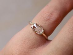 a woman's hand with a ring on it that has a stone in the middle