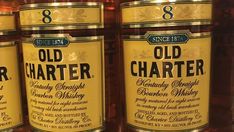 three bottles of old charter whiskey sitting next to each other