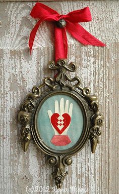 an ornate frame with a red ribbon hanging from it's side on a wall