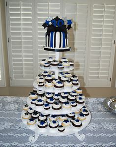 a cake and cupcakes are arranged on a table in front of shutters