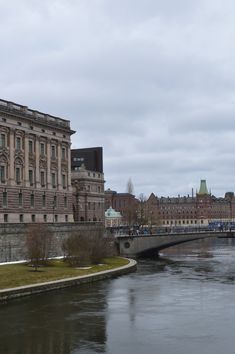 an old building next to a river and bridge