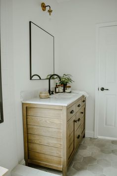 a bathroom with a sink, mirror and tiled floor