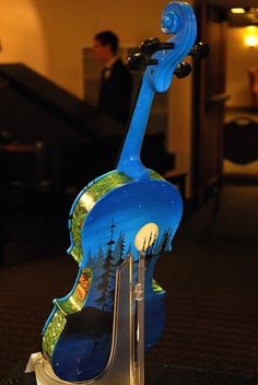 a blue violin sculpture sitting on top of a glass table next to a stair case