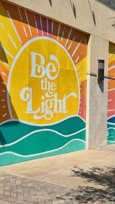 a mural on the side of a building that says be the light with sun above it