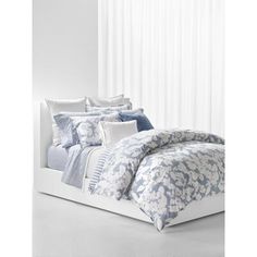 a bed with blue and white comforters in a room