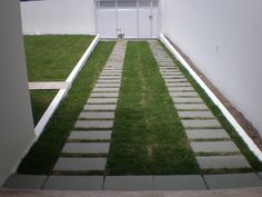 an open door leading to a small yard with grass growing on the lawn and steps