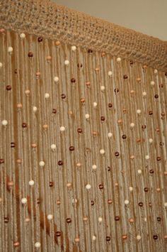 a close up view of some beads on a curtain in a room with white walls