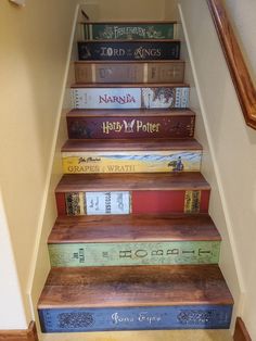 a set of stairs with books painted on the bottom and bottom, in various colors