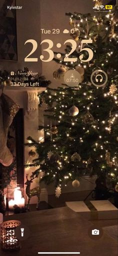 a christmas tree is lit up in the living room with candles and decorations on it