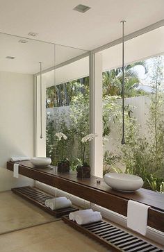 a bathroom with two sinks and large windows