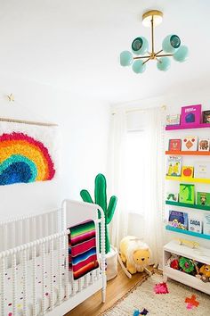 a child's room with white walls and colorful decorations on the wall, including a crib