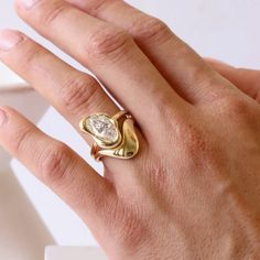 a person's hand with a gold ring on it