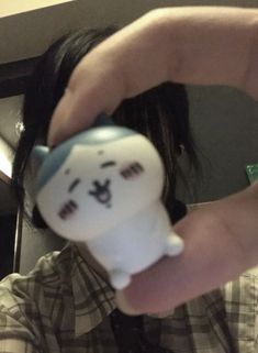 a person holding a toy in their hand with a smile on it's face