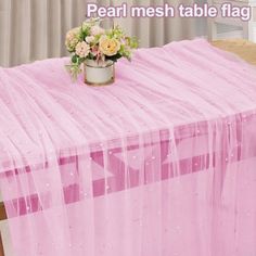 a pink table cloth with flowers in a tin can on it and the words pearl mesh table flag