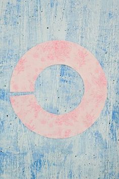 a pink circle painted on the side of a blue wall