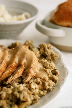 a white plate topped with meat covered in gravy