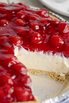 a cheesecake covered in cherries on top of a table