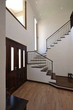 an empty room with wooden floors and stairs