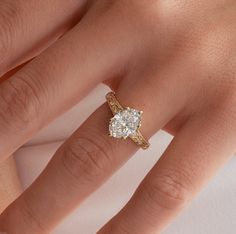 a woman's hand with a diamond ring on top of her finger and an engagement band