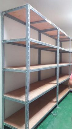 a man is standing in front of shelves with empty shelves on each side and another shelf behind him