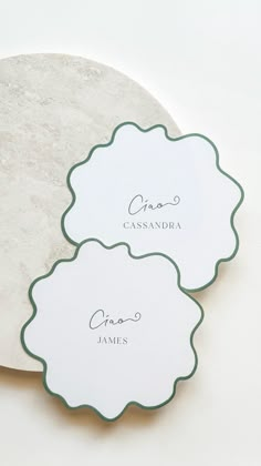 two white and green place cards on a marble platter