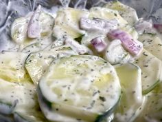 cucumbers and onions are mixed together in a sauce that is drizzled over them