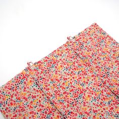 three pieces of fabric with small flowers on them, one is red and the other is blue