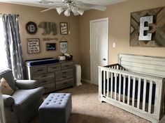 a baby's room with a crib, chair, dresser and window in it