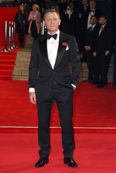 a man in a tuxedo standing on a red carpet