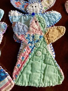 several handmade baby bibs on a table with one stuffed animal in the middle