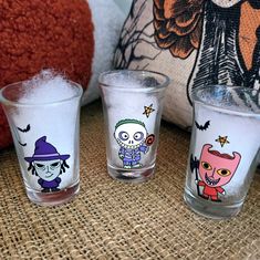 three shot glasses decorated with cartoon characters