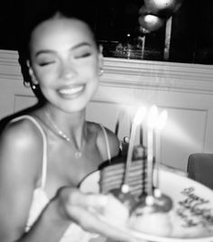 a woman holding a cake with candles on it