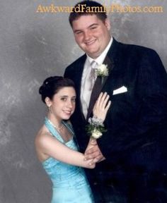 a man in a suit and woman in a blue dress are posing for a photo