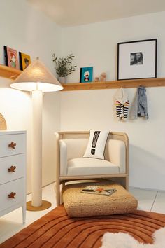 a white chair sitting on top of a rug next to a lamp