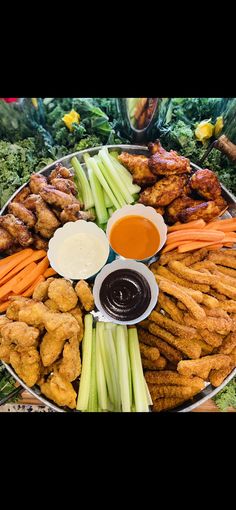 a platter filled with chicken wings, carrots, celery and dipping sauce